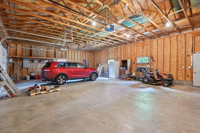 garage with a garage door opener and electric panel