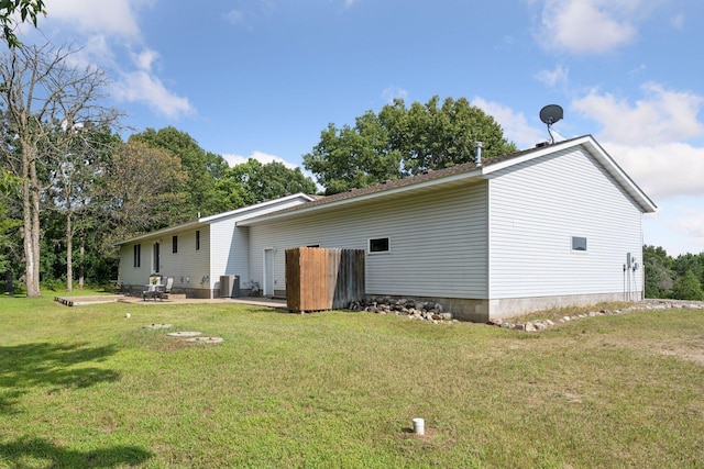 back of house with central air condition unit, a lawn, and a patio