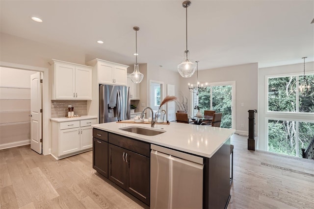 kitchen with white cabinetry, a chandelier, appliances with stainless steel finishes, and pendant lighting