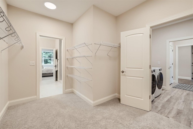 laundry room featuring light carpet and washing machine and dryer