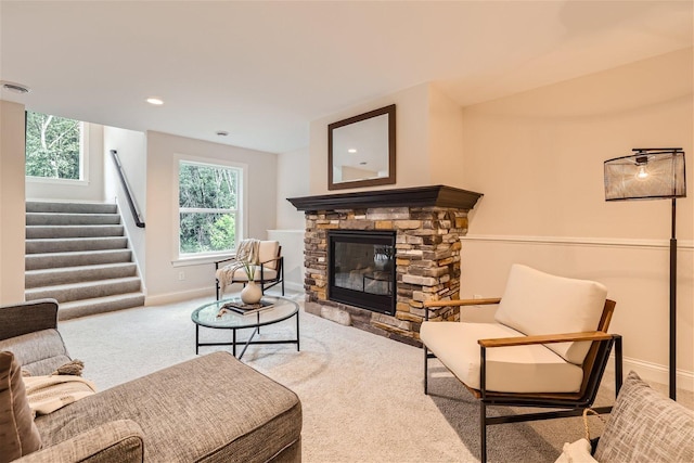 living room featuring a fireplace and light colored carpet