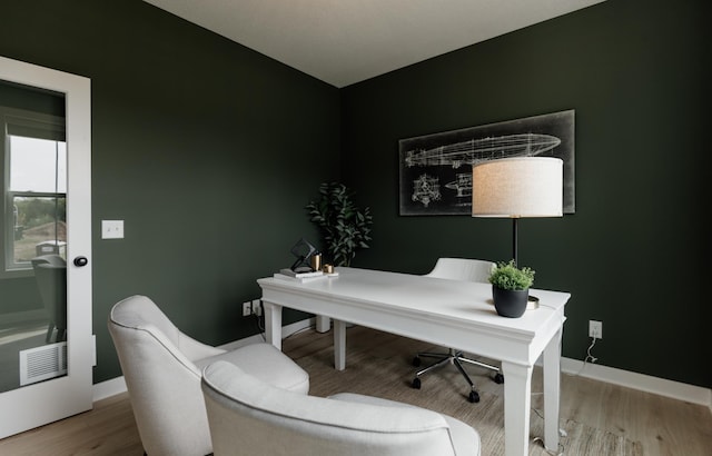 office featuring visible vents, baseboards, and wood finished floors