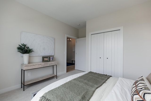 bedroom with carpet floors, baseboards, and a closet