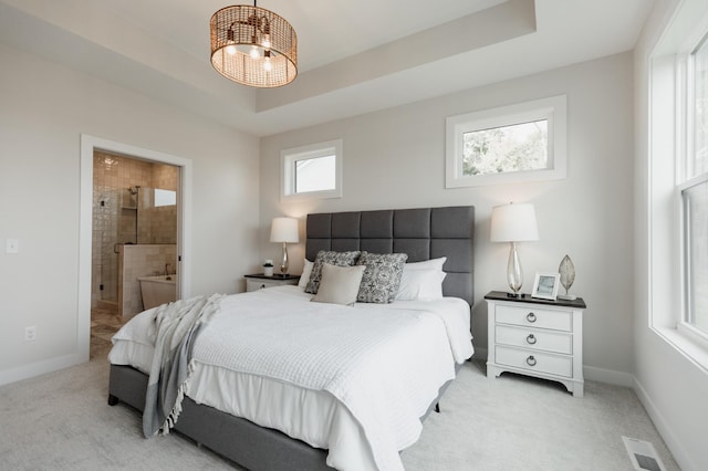 bedroom featuring light colored carpet, a raised ceiling, visible vents, and baseboards