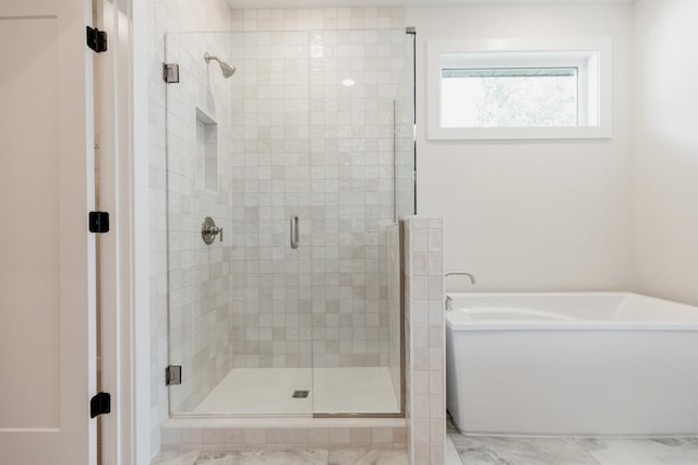 bathroom featuring a freestanding tub and a shower stall