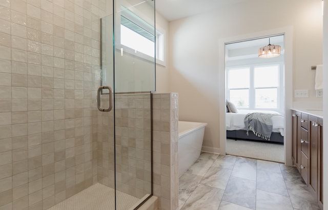 ensuite bathroom with a stall shower, a freestanding tub, a healthy amount of sunlight, and ensuite bathroom