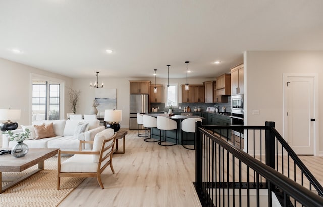 living room with recessed lighting, a notable chandelier, and light wood finished floors