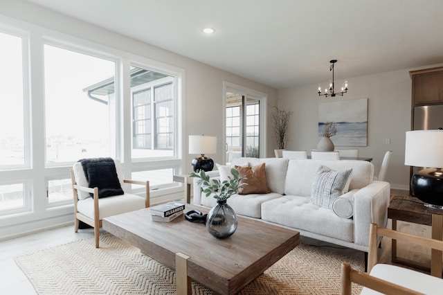 living room with recessed lighting, a healthy amount of sunlight, and a notable chandelier