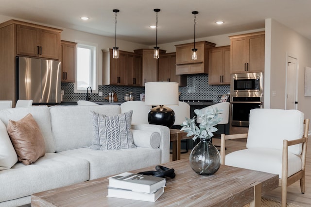 living room with light wood-style flooring and recessed lighting