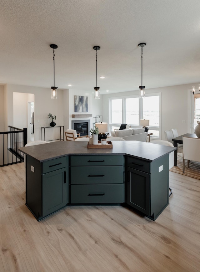 kitchen featuring light wood-style floors, a wealth of natural light, open floor plan, and a center island