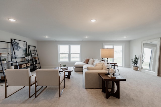 living area featuring light carpet, recessed lighting, and a healthy amount of sunlight