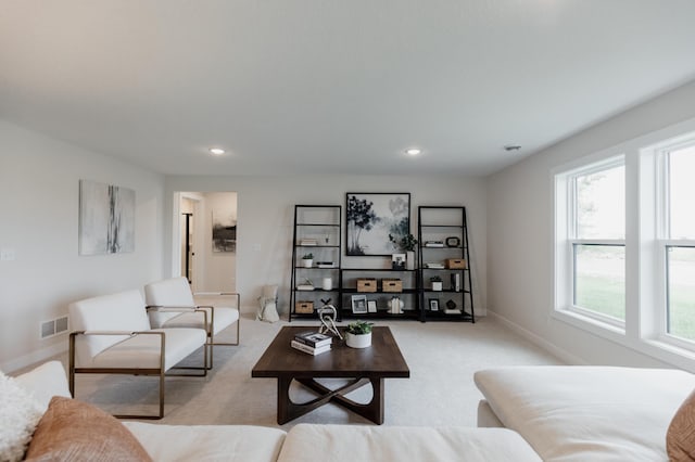 living area with baseboards, recessed lighting, visible vents, and light colored carpet