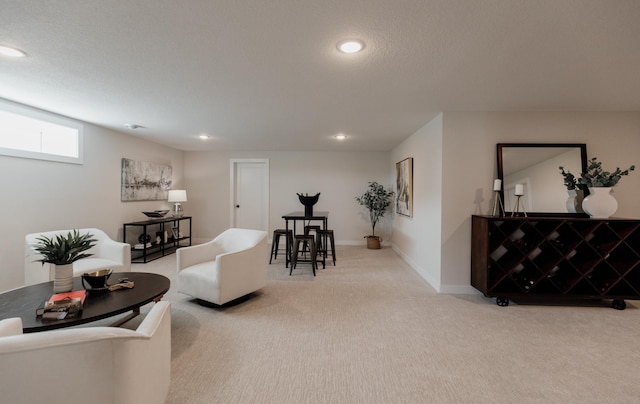 carpeted living area with recessed lighting, a textured ceiling, and baseboards