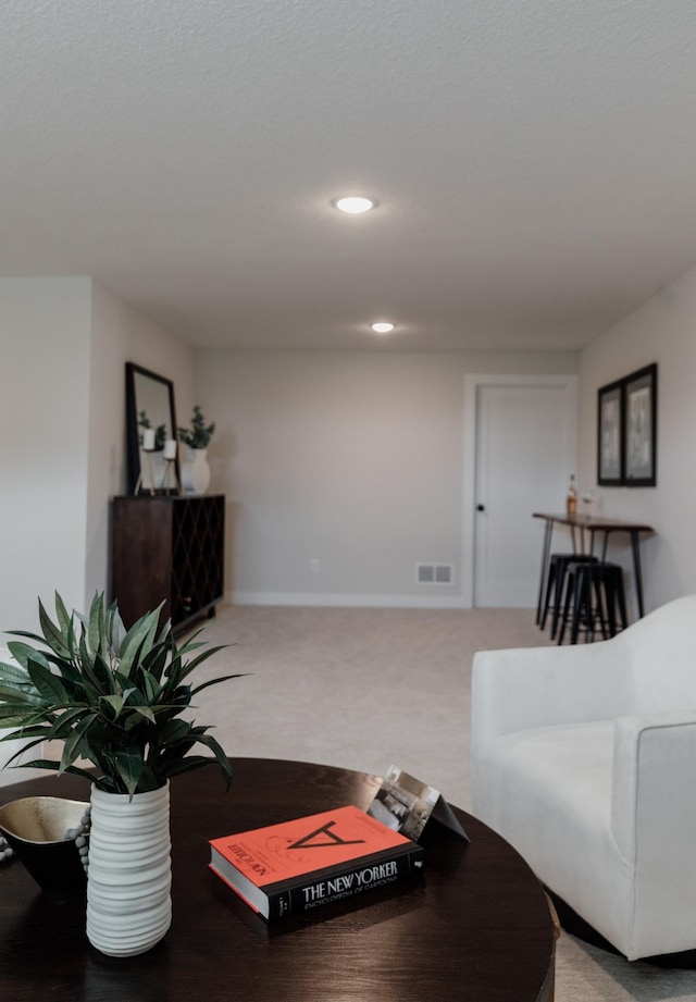 living area featuring light colored carpet, recessed lighting, visible vents, and baseboards