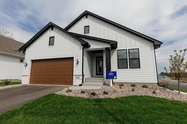 modern inspired farmhouse featuring driveway, a garage, a front lawn, and board and batten siding