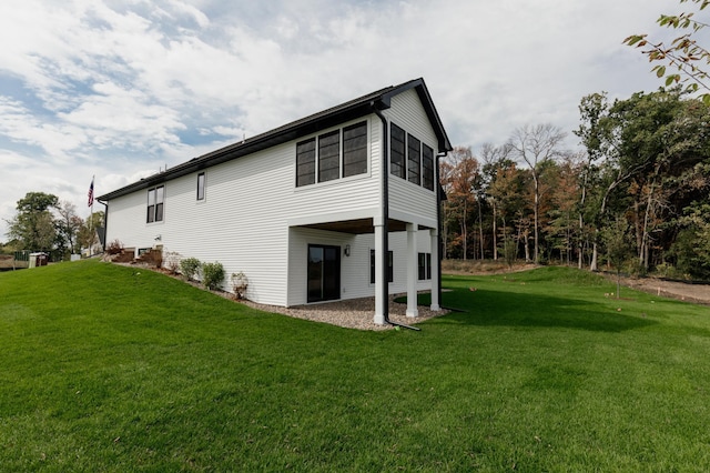 rear view of property featuring a carport and a lawn