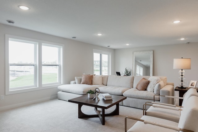 carpeted living area with recessed lighting and baseboards