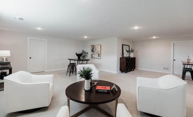 living room featuring light carpet, baseboards, visible vents, and recessed lighting