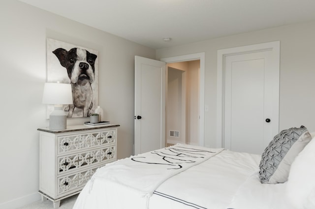 bedroom featuring visible vents and light carpet