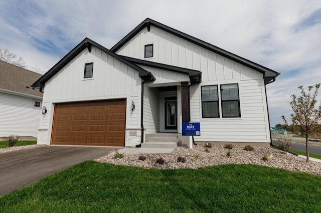 view of front of property featuring driveway, board and batten siding, and a front lawn