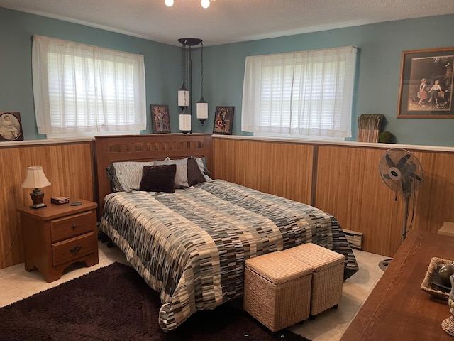 bedroom with wood walls and a textured ceiling