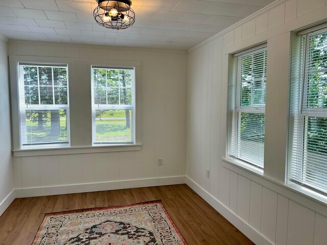 unfurnished room with baseboards, ornamental molding, and light wood-type flooring