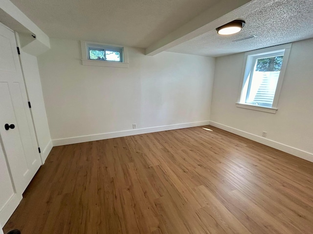 basement featuring wood-type flooring and a textured ceiling