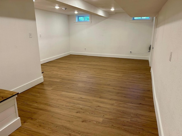 below grade area featuring baseboards and wood finished floors