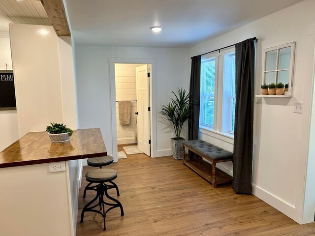 dining space with baseboards and light wood-type flooring