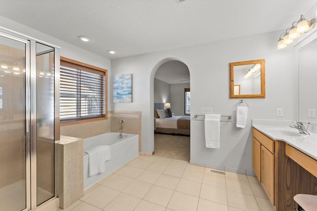 bathroom with vanity, tile patterned flooring, independent shower and bath, and a textured ceiling