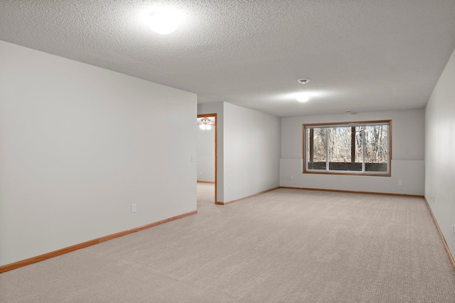 empty room with light carpet and a textured ceiling