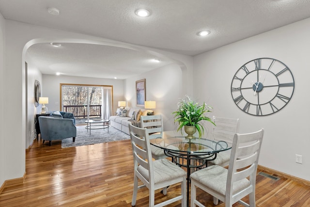 dining space featuring hardwood / wood-style floors and a textured ceiling