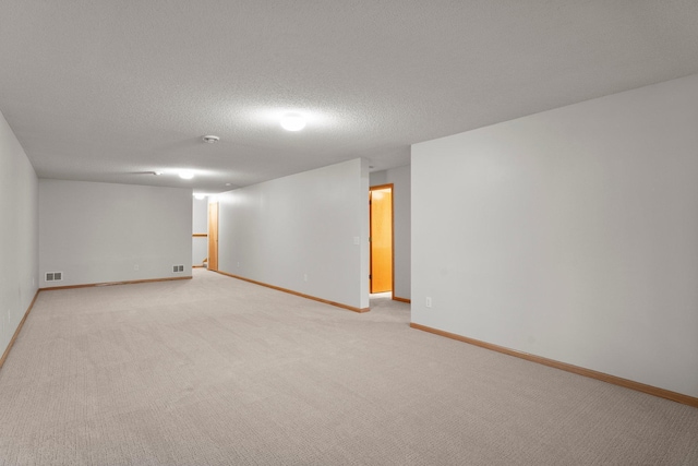 carpeted empty room featuring a textured ceiling