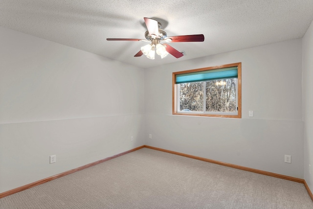 empty room featuring ceiling fan, carpet floors, and a textured ceiling