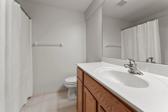 bathroom with vanity, toilet, tile patterned flooring, and a textured ceiling