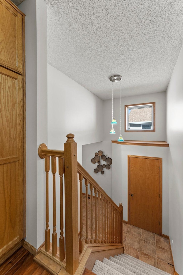 staircase with a textured ceiling