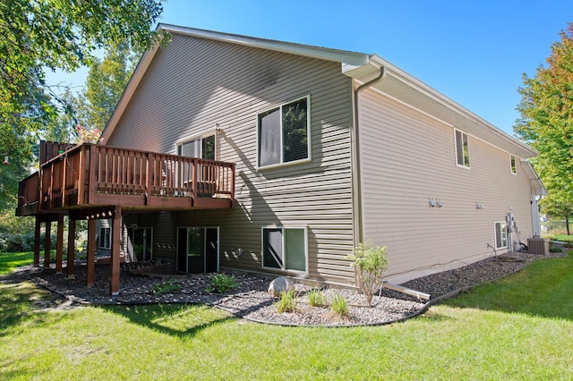 back of property with a wooden deck, central AC, and a lawn