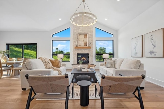 living room featuring high vaulted ceiling, light wood-type flooring, and a healthy amount of sunlight