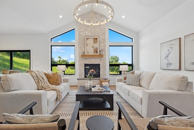 living room featuring a chandelier, wood finished floors, a stone fireplace, high vaulted ceiling, and recessed lighting