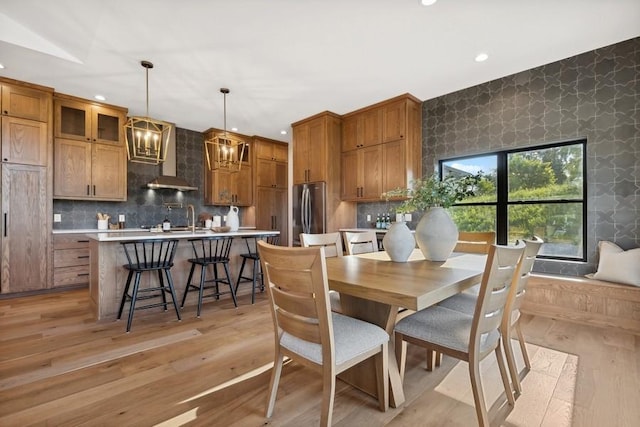 dining area featuring a chandelier, wallpapered walls, light wood-type flooring, and recessed lighting