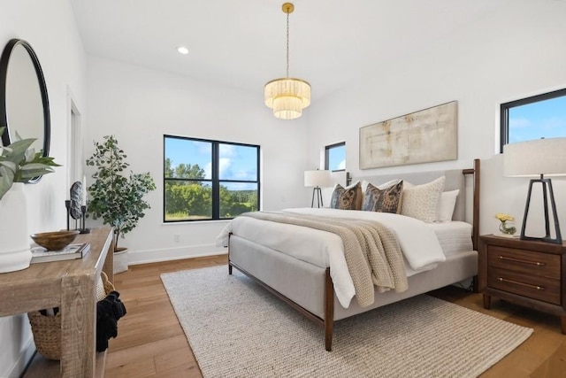 bedroom with baseboards, multiple windows, wood finished floors, and recessed lighting