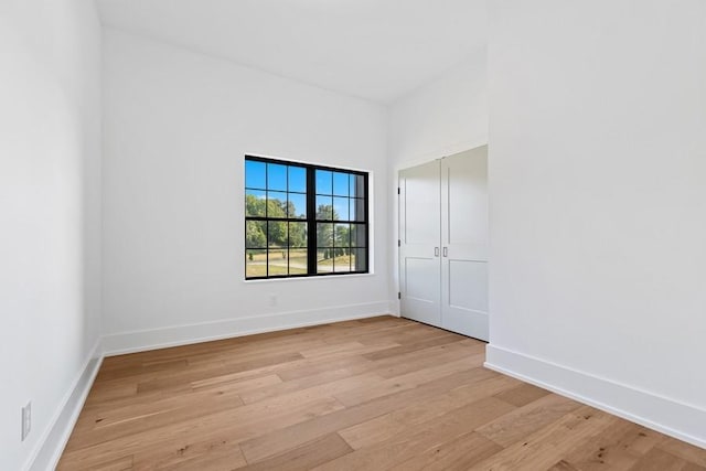 spare room with light wood-type flooring and baseboards