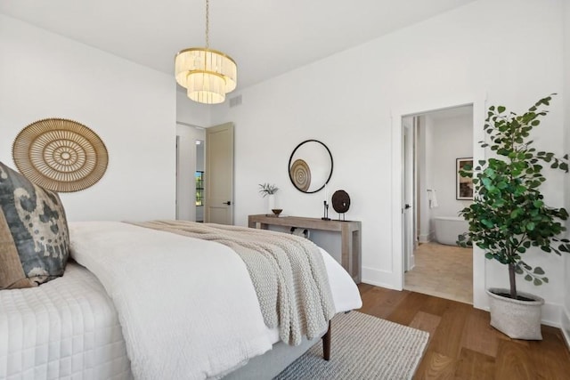 bedroom featuring wood finished floors, visible vents, and baseboards