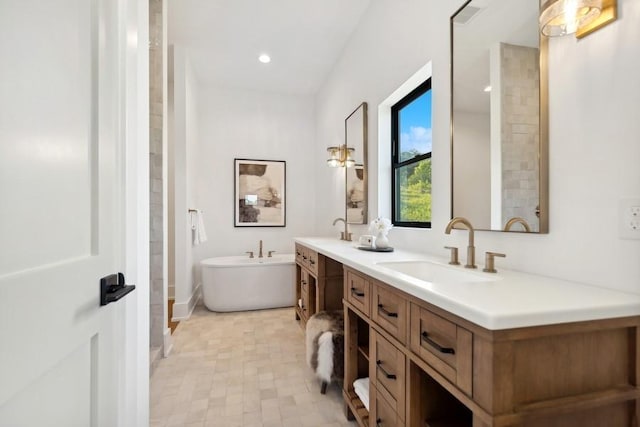 bathroom featuring recessed lighting, a soaking tub, a sink, and double vanity