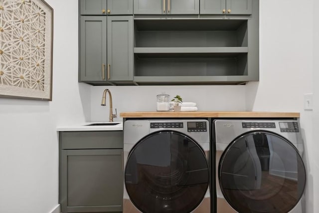 laundry area featuring a sink, cabinet space, and washer and dryer