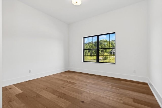 empty room with baseboards and wood finished floors