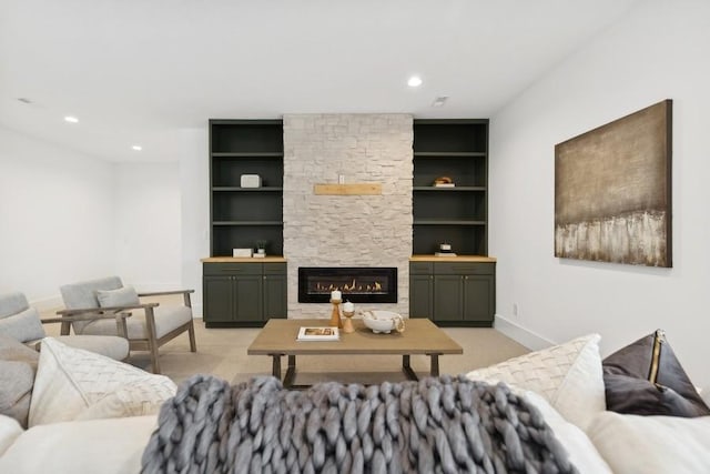 living area featuring built in features, recessed lighting, light carpet, a stone fireplace, and baseboards