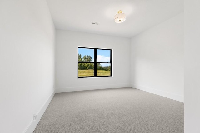 spare room featuring light carpet, baseboards, and visible vents