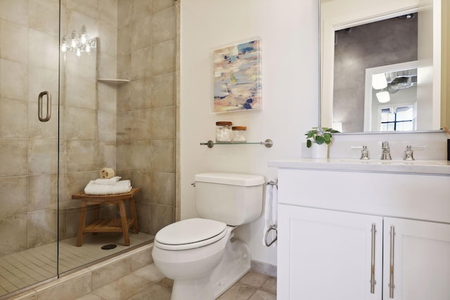 bathroom with vanity, tile patterned floors, a shower with door, and toilet