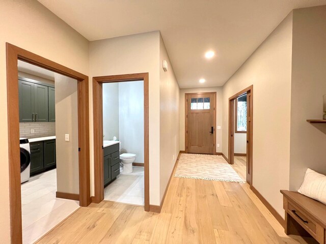 doorway to outside featuring washer / clothes dryer and light wood-type flooring